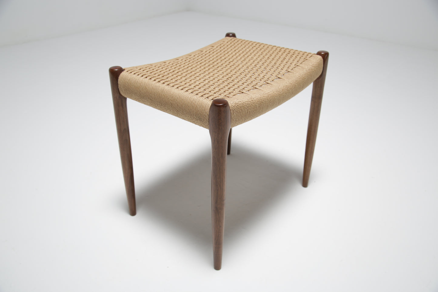 A walnut and papercord stool by Niels Moller.